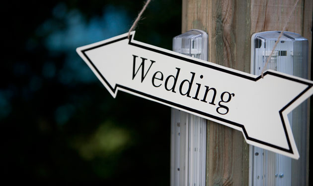 white direction arrow pointing to the left with the word wedding
