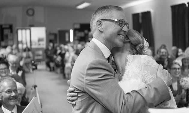 reportage photo of bride hugging groom seconds after being named man and wife