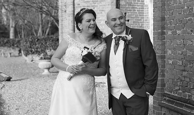 candid image of bride and groom at foot of tower at Leez Priory Chelmsford