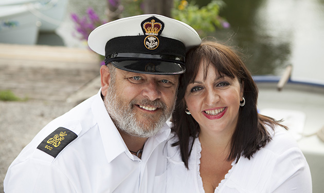 man in white sailor uniform with future bride in white boat in background