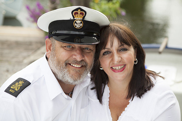 sailor in uniform with future bride in white boat in background