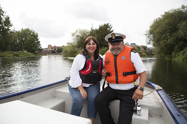 couple on boat in middle of river wearing orange life vests