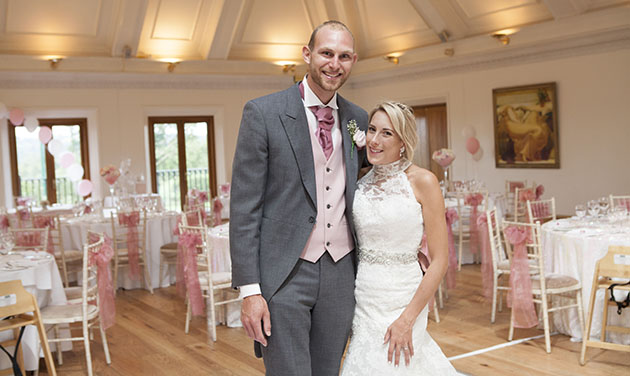 Newlyweds at Stock Brook wedding venue with decorated room in the background