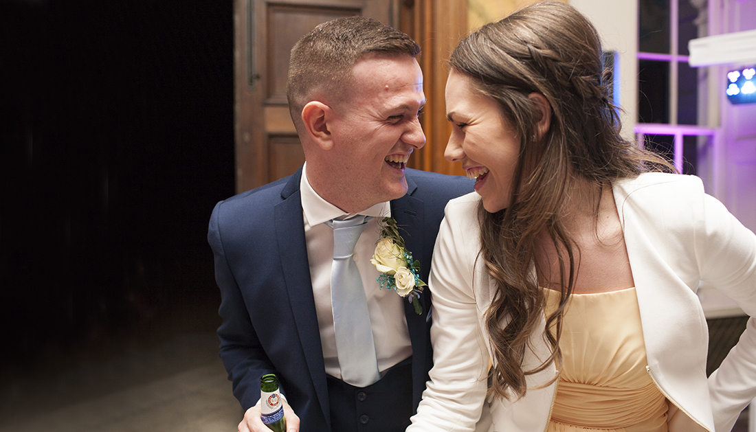 two people looking at each other and laughing during the wedding party at Hylands House Essex