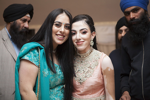 Two young Sikh girls in traditional dress looking at the camera