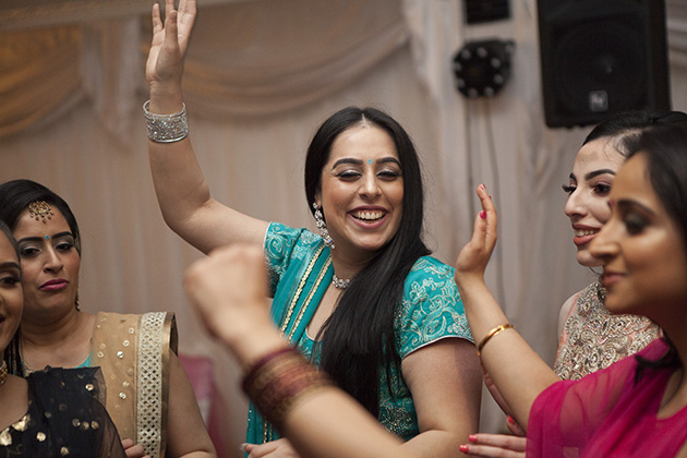 Women dancing with hands in the air at an Indian birthday party
