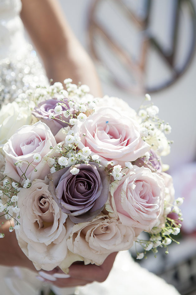 close up of a bride holding a bouquet of flowers with VW badge in background