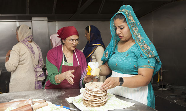 Indian women in a kitchen making chapati