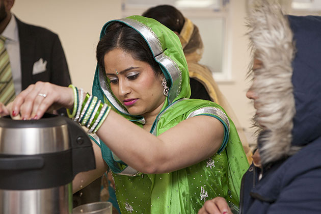 Indian woman in green dress serving tea