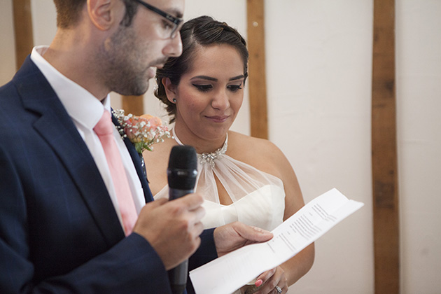 Groom reading a speech as his wife looks on