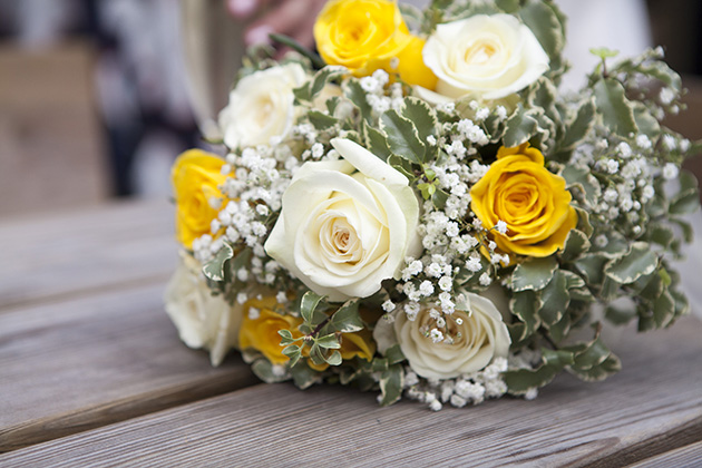 Yellow and white bouquet of wedding flowers on wooden table