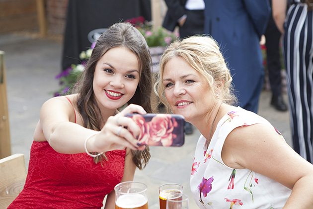 Two female wedding guests taking a selfie