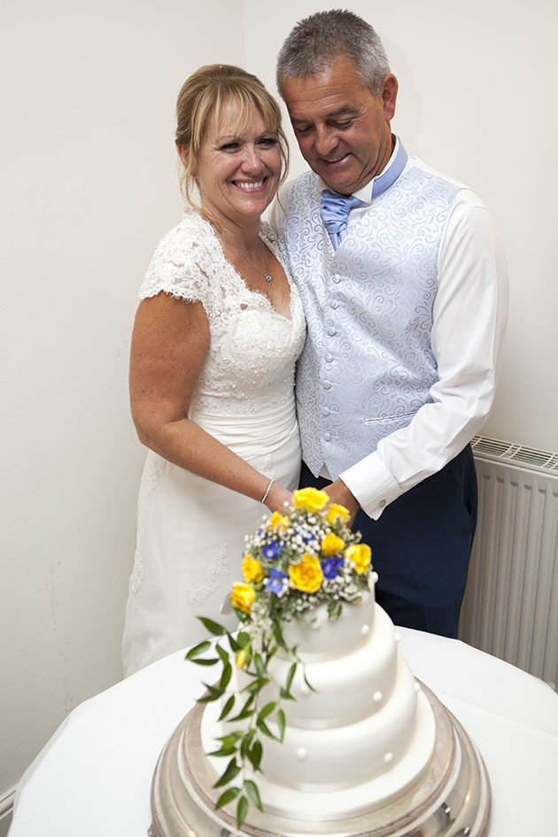 Newlyweds cutting wedding cake
