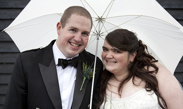 Bride and groom under an umbrella