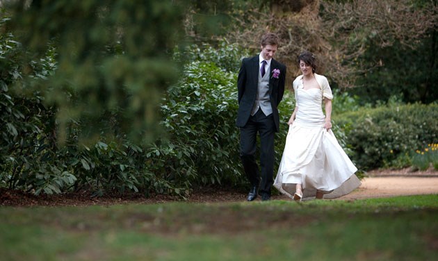 distance photo of bride and groom walking in grounds of Hylands House Essex