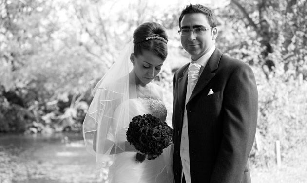 black and white photo of bride and groom standing by fountain at Channels Estate Essex