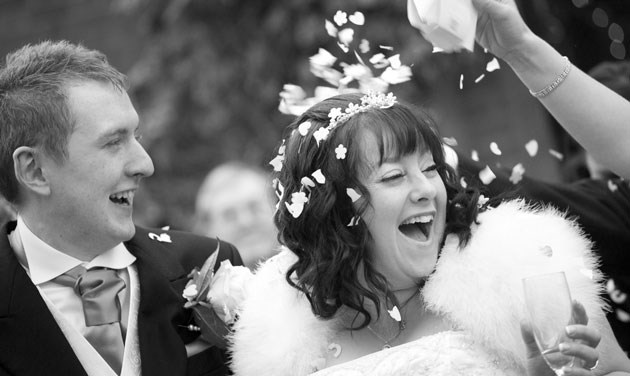 guest throwing confetti over the head of the bride