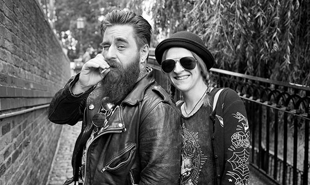Camden Town street portrait of bearded man in leather jacket smoking with girlfriend