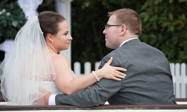 profile photo of bride with her arm on groom's arm and looking each other