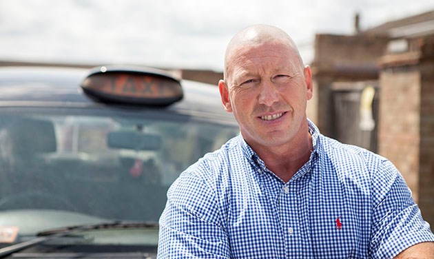 portrait of black cab driver looking at camera