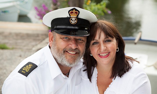 man in white sailor uniform with future bride in white boat in background