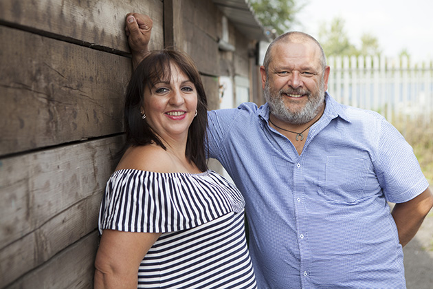 man and woman standing by shed in boatyard