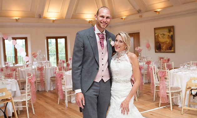 Newlyweds at Stock Brook wedding venue with decorated room in the background