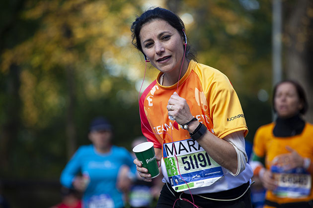 New York marathon runner in orange looking at camera