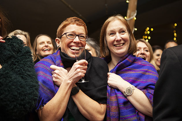 Two women at a social function and smiling