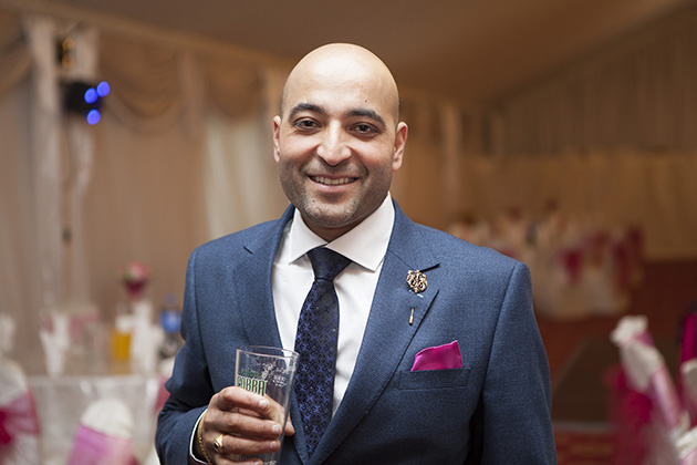 Man holding a pint of beer looking at camera