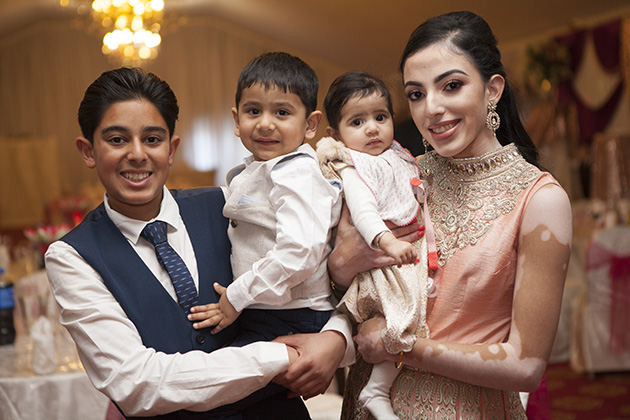 Relaxed portrait of two teenagers and two small children all looking at camera