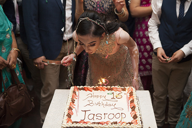 Young girl blowing out candle on a large birthday cake