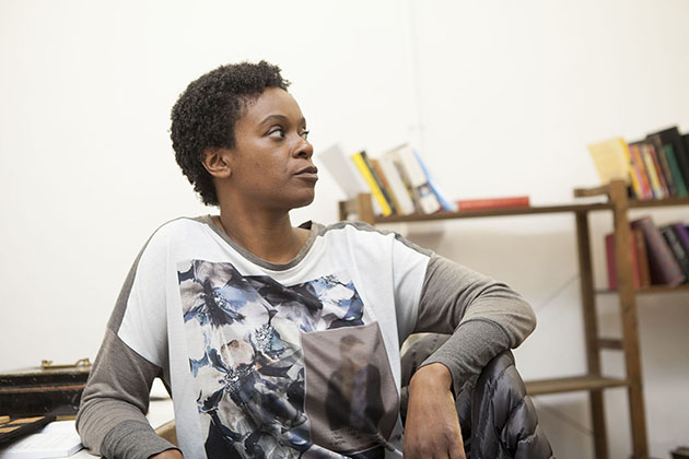 Actor Valerie Paul in rehearsal sitting on a chair and looking to the side