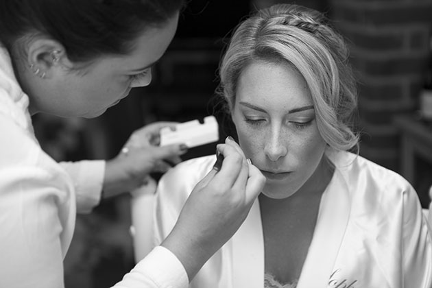 bride getting ready and having eye make-up applied at home