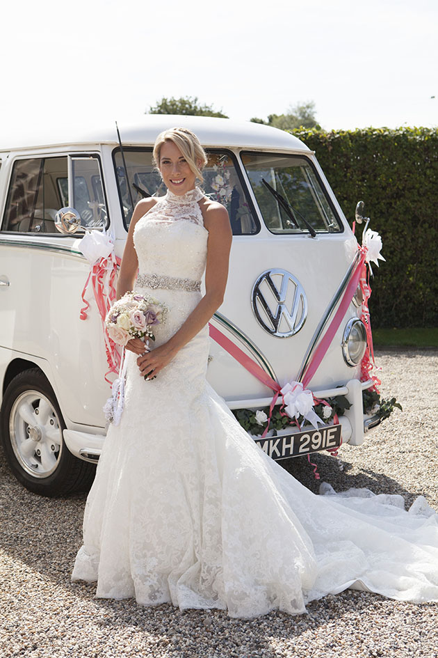 bride holding bouquet and standing in front of VW kombi van