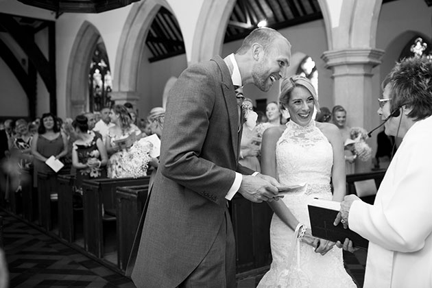 bride and groom laughing during Roxwell church wedding ceremony with congregation behind them
