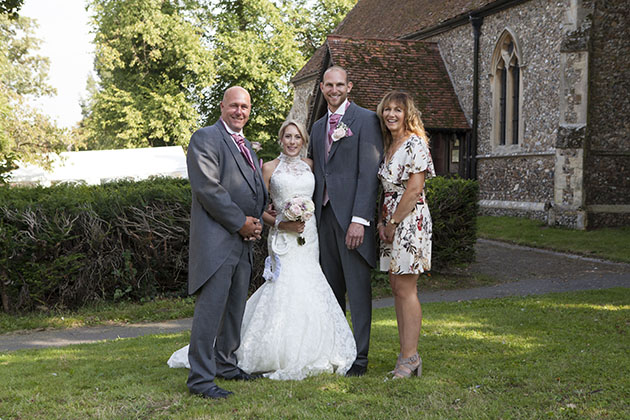 small family wedding group photo in the grounds of an Essex church