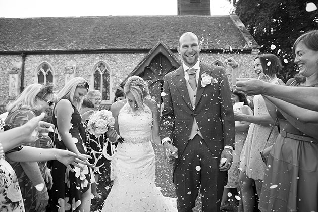 bride and groom at the end of a line of people throwing confetti
