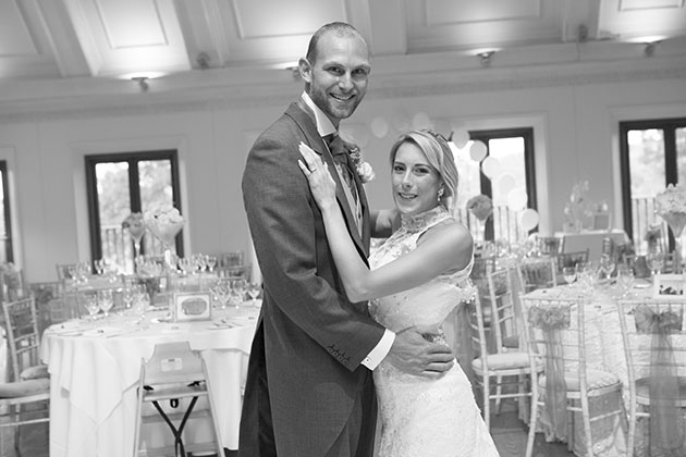 bride and groom facing each other with the decorated room at Stock Brook Country Club Essex in the background