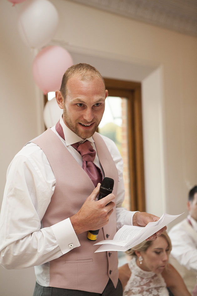 groom standing with microphone doing his wedding speech