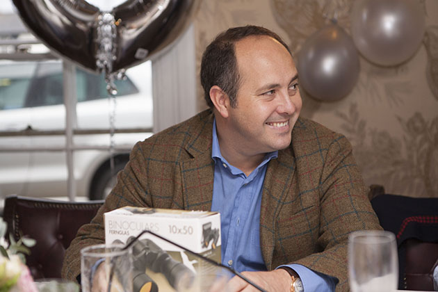 Man at a table in a restaurant looking to the side and smiling