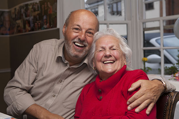 Man with his arms around na older woman at a family party