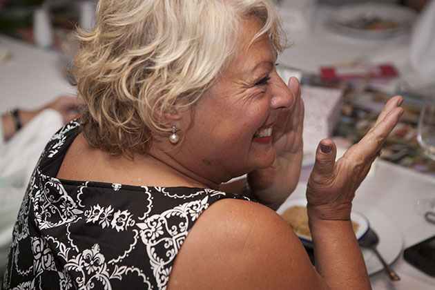 Woman at a restaurant table clapping hands and laughing