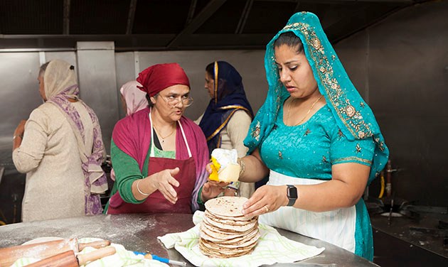 Indian women in a kitchen making chapati