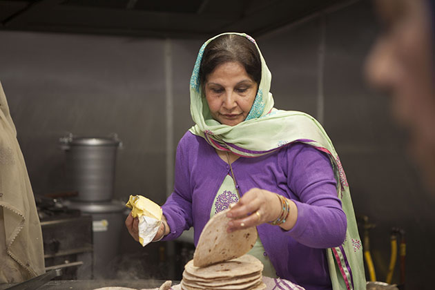 Indian woman making chapati in large kitchen
