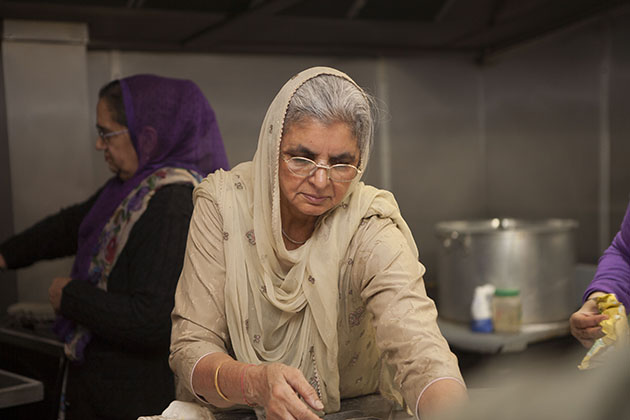 Indian woman making chapati in large kitchen