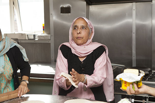 Indian woman making chapati in large kitchen