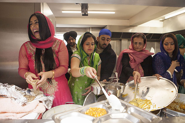 Indian people serving food at kitchen hatch