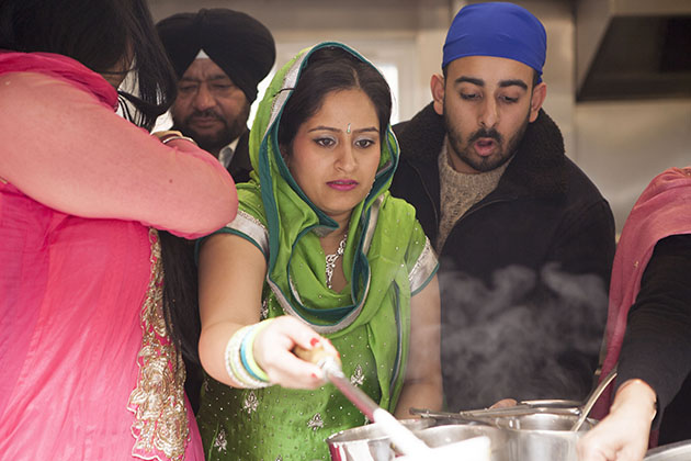 Woman serving hot food from a kitchen hatch