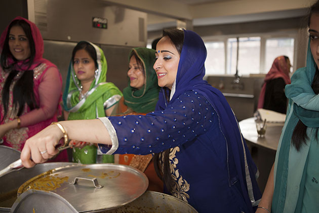 Women serving hot food from a kitchen hatch